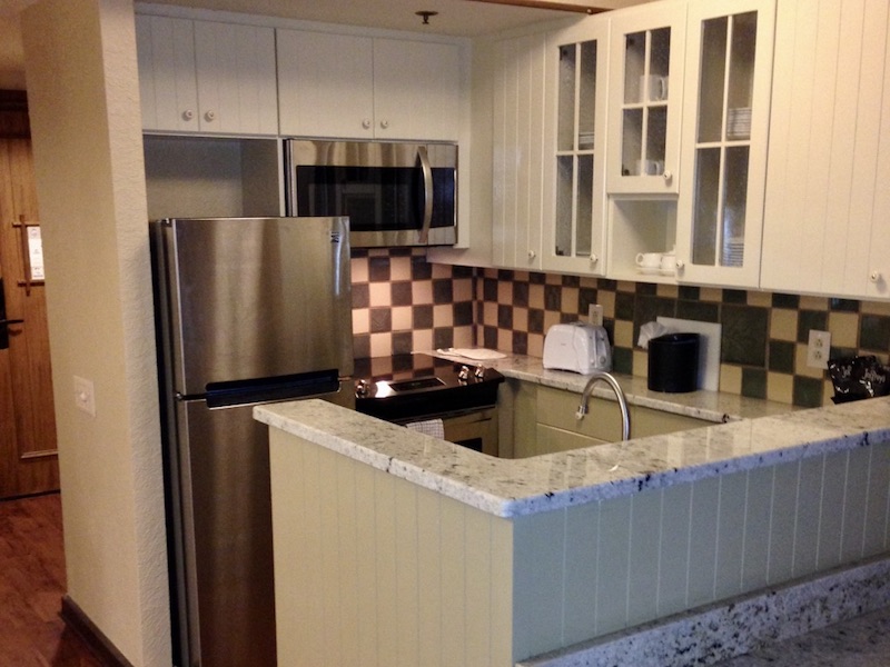 Kitchen highlighting refrigerator, stove and microwave